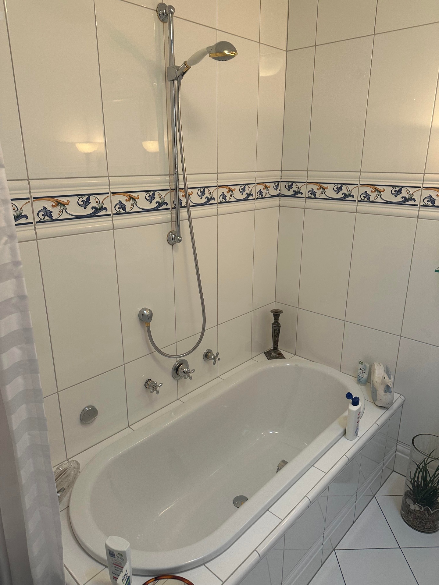 Altes Bad mit weißen Fliesen, Ornamentbordüre und Badewanne
